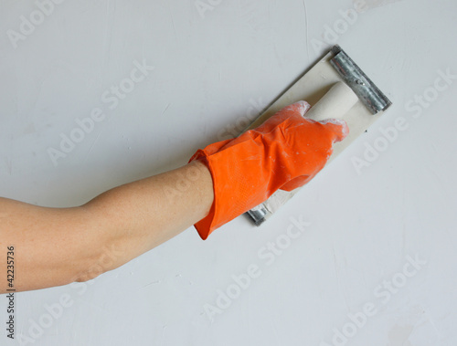 Photo: Plasterer smoothing out wall with trowel Plasterer smoothing out wall with trowel