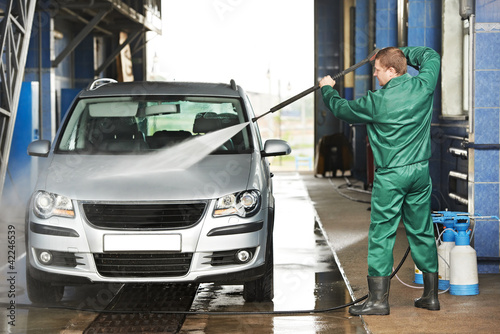 Photo: worker cleaning car with pressured water worker cleaning car with pressured water