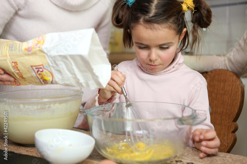 Photo: Young girl learning how to cook Young girl learning how to cook