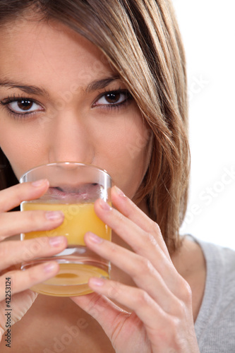 Photo: Woman drinking a glass of orange juice Woman drinking a glass of orange juice