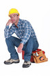 Bored builder sat on tool-box