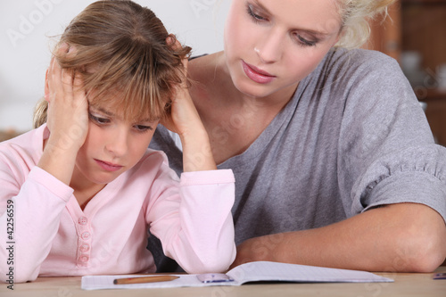 Photo: Mother helping her daughter with her homework. Mother helping her daughter with her homework.