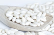 Photo: White beans on wooden spoon and a white background White beans on wooden spoon and a white background