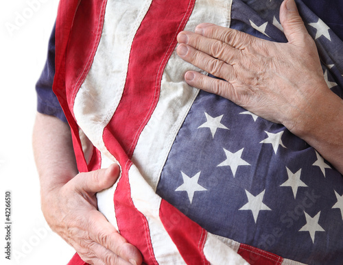 Photo: man holds American flag close to his body man holds American flag close to his body