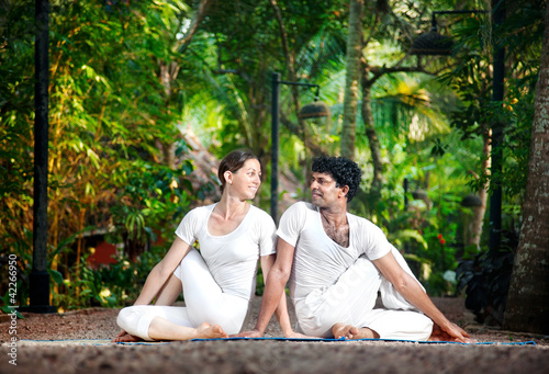 Photo: Couple yoga matsyendrasana pose Couple yoga matsyendrasana pose