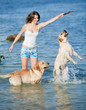 Girl playing with dog at the sea