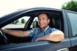 Young man in car smiling