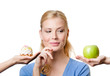 Foto: Beautiful woman makes a tough choice between cake and apple Beautiful woman makes a tough choice between cake and apple