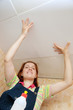Woman glues ceiling tile