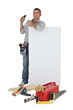 Carpenter pointing to mobile telephone