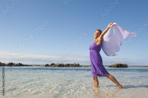 Photo: Pretty woman feeling free and happy at beach Pretty woman feeling free and happy at beach