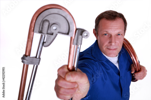 Photo: Plumber bending copper piping Plumber bending copper piping