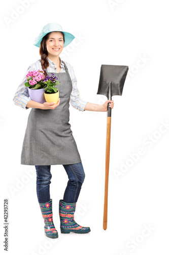 Photo: Full length portrait of a female worker holding a shovel Full length portrait of a female worker holding a shovel