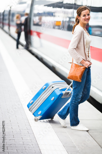 Foto: Pretty young woman at a train station (color toned image) Pretty young woman at a train station (color toned image)