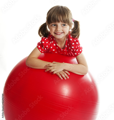 Photo: little girl doing fitness exercise with a red ball little girl doing fitness exercise with a red ball