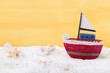 Rotes Segelboot aus Holz am Strand