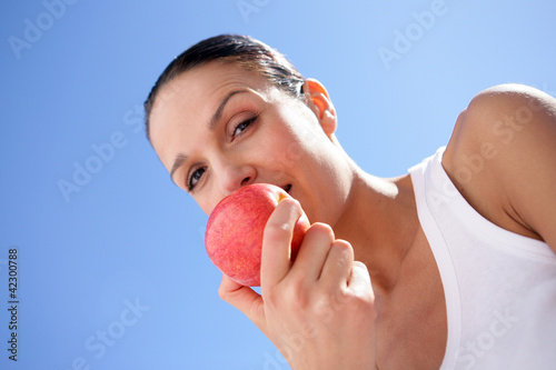 Foto: Brunette biting into red apple Brunette biting into red apple