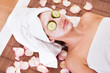 Beautiful young woman getting facial mask