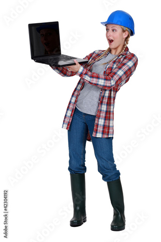 Photo: Female builder surprised by laptop Female builder surprised by laptop