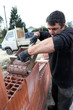 Mason pouring cement on wall
