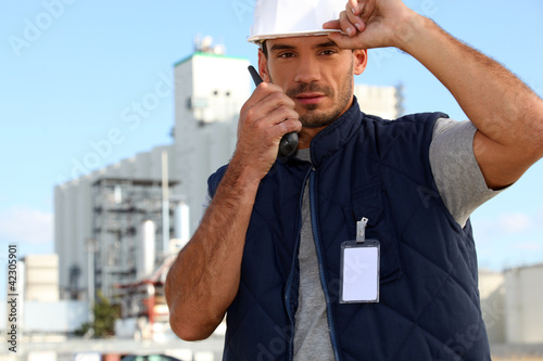 Photo: Construction worker speaking into his walkie-talkie Construction worker speaking into his walkie-talkie