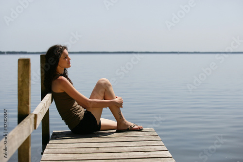 Foto: Woman sitting on a pontoon Woman sitting on a pontoon