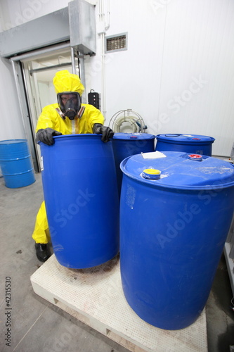 Foto: worker in uniform dealing with barrels of hazardous substance worker in uniform dealing with barrels of hazardous substance