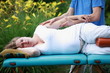 physical therapist massaging pregnant woman's arm