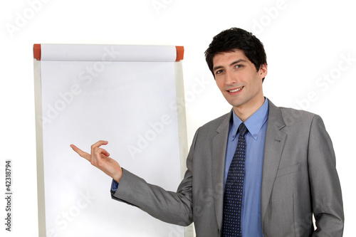 Photo: handsome executive pointing at board handsome executive pointing at board
