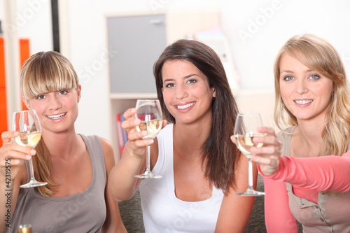 Foto: Three women toasting with glass of wine Three women toasting with glass of wine