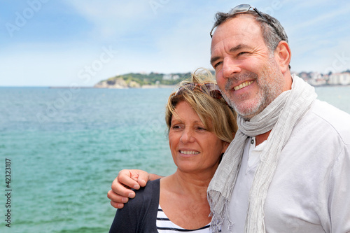 Foto: Portrait of senior couple standing by the sea Portrait of senior couple standing by the sea