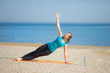 Young woman doing yoga on beach