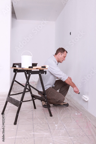 Photo: Man painting a wall Man painting a wall