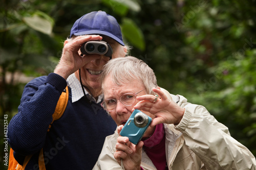 Photo: Couple Using Camera and Binoculars Couple Using Camera and Binoculars