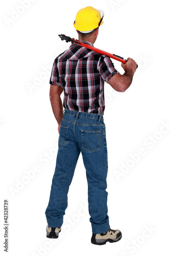 Photo: Man holding wrench with back turned Man holding wrench with back turned