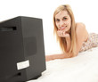 young woman lying on the floor and watching television