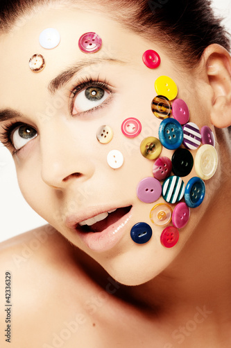 Foto: Beautiful woman with buttons on her face Beautiful woman with buttons on her face