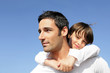 Photo: Boy riding piggy back on his father's back Boy riding piggy back on his father's back