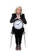 Woman sitting with a clock on her knees