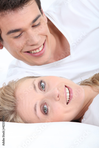 Foto: Smiling young couple lying down Smiling young couple lying down