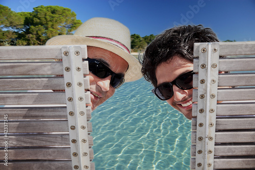 Photo: Father and son sat poolside Father and son sat poolside