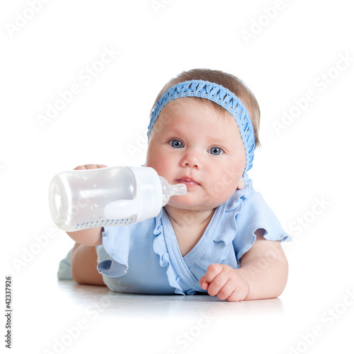 Photo: adorable child drinking from bottle. 8 months old girl. adorable child drinking from bottle. 8 months old girl.