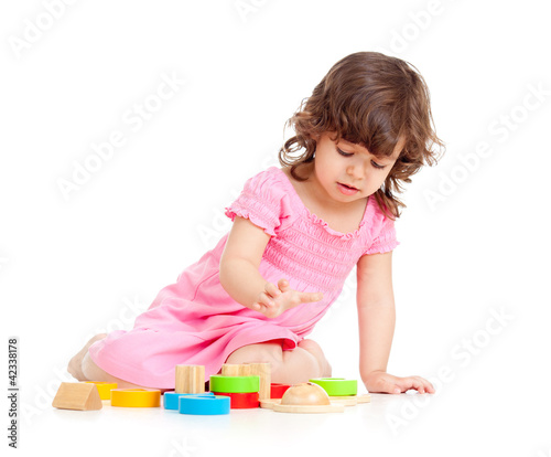 Photo: cute kid girl playing with colorful toys, isolated over white cute kid girl playing with colorful toys, isolated over white