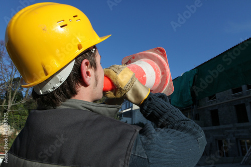 Photo: Construction worker shouting through cone Construction worker shouting through cone