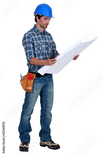Foto: Tradesman examining a blueprint Tradesman examining a blueprint