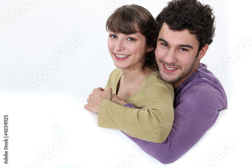 Foto: Couple hugging on a white sofa Couple hugging on a white sofa