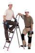 two workers posing with drills
