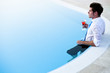 Photo: Young man having drink in the pool Young man having drink in the pool