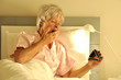 Foto: Seniorin im Bett mit Wecker Seniorin im Bett mit Wecker