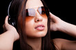 Photo: Beautiful young woman listening to music with headphones on blac Beautiful young woman listening to music with headphones on blac